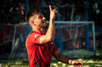 Jugador de fútbol señalando arriba con el dedo durante un partido.