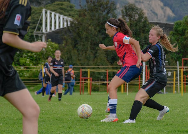 Mujeres futbolistas profesionales jugando a fútbol.