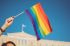 Mano alzando una bandera arcoíris o bandera del orgullo LGTB+ creada para luchar por la discriminación laboral LGTB+.