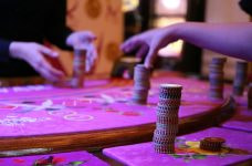 Recogiendo fichas de un tapete de juego para recuperar dinero perdido en el casino.