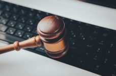Mazo de un juez golpeando el teclado de un ordenador de sobremesa.