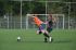 Dos jugadoras de fútbol tropezándose entre sí mientras corren por el campo detrás del balón.