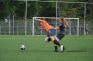 Dos jugadoras de fútbol tropezándose entre sí mientras corren por el campo detrás del balón.