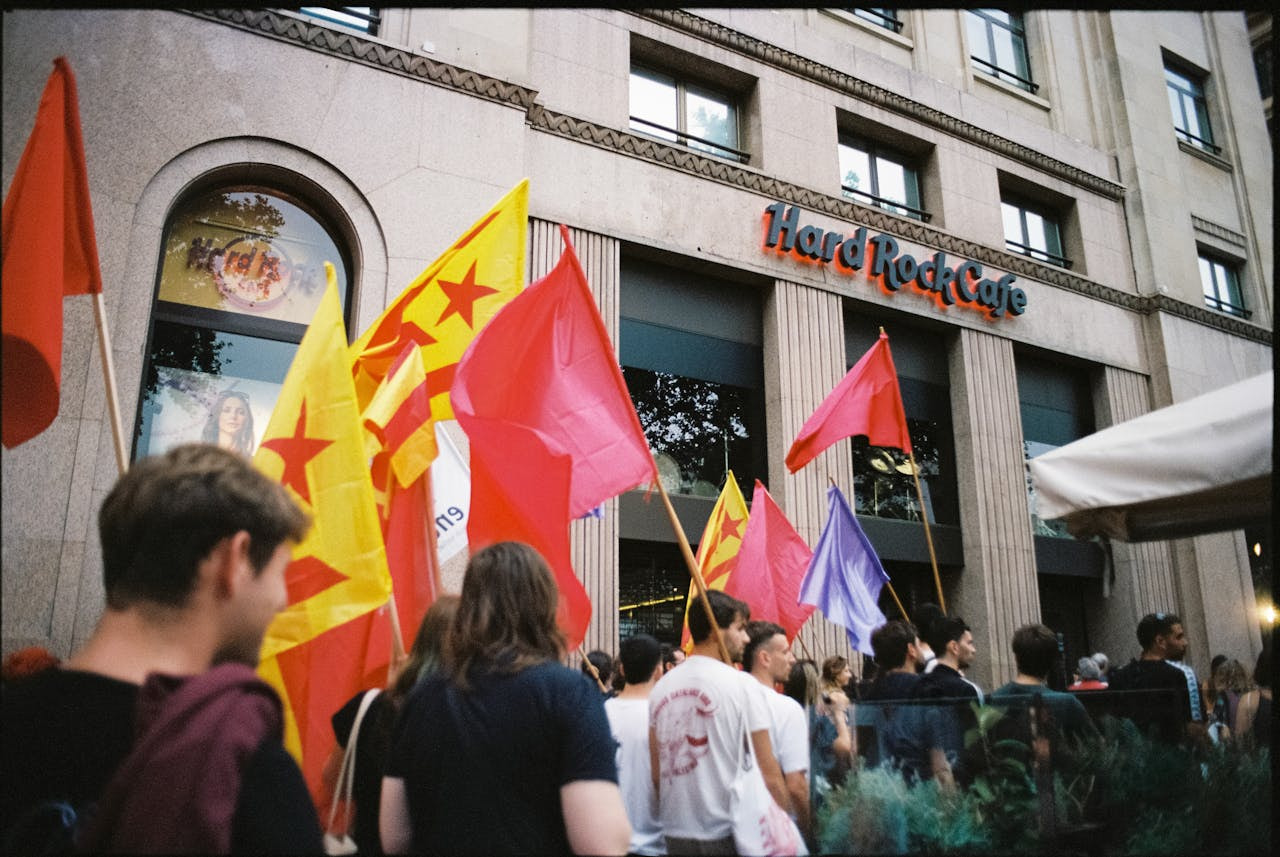 Manifestantes con banderas en señal de protesta delante de la fachada de Hard Rock Tarragona.