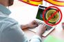 Persona jugando en un casino online y un símbolo de Bitcoin prohibido.