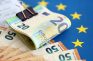 Billetes de euro sobre una bandera de la Unión Europea.