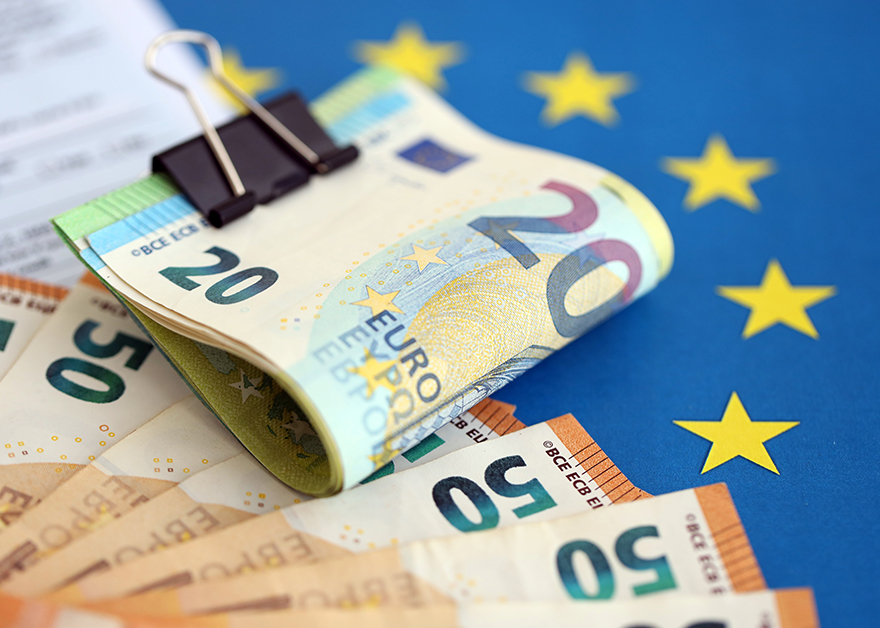 Billetes de euro sobre una bandera de la Unión Europea.