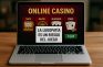 Pantalla de casino online en un portátil con mensaje de advertencia sobre ludopatía.