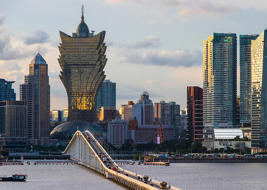 Vista de la ciudad de Macao con sus icónicos casinos iluminados al atardecer.