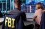 Agentes del FBI observando múltiples pantallas con datos mientras trabajan en un centro de control.