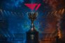 Trofeo del campeonato mundial de League of Legends en un escenario iluminado con el logo de T1 sobre él.