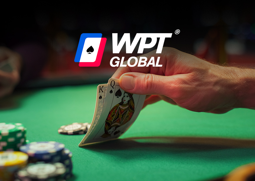 Mano levantando cartas sobre mesa de póker con logo “WPT Global”.
