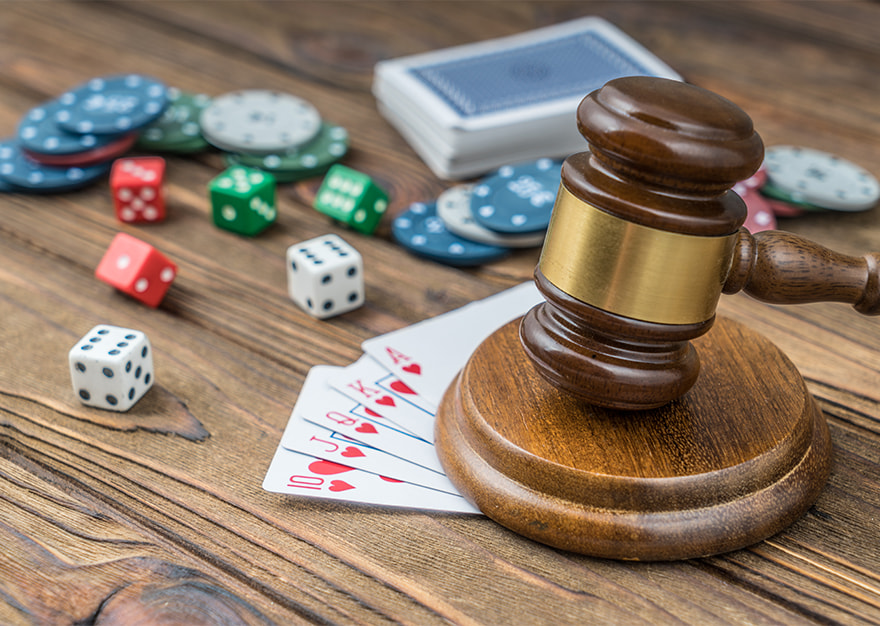 Mazo judicial junto a cartas, dados y fichas de casino.
