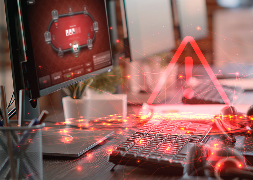 Teclado y ordenador con icono de alerta roja y pantalla de póker.