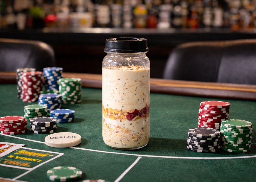 Tarro de avena sobre mesa de póker con fichas y tapete verde.