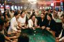 Grupo de mujeres jugando en mesa de casino con crupier.