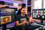 Streamer hablando ante micrófono con pantallas de casino online y videollamada.