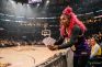Mujer con camiseta de los Lakers sosteniendo entradas junto a la pista de baloncesto.