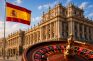 Bandera de España junto a ruleta y edificio institucional gubernamental.
