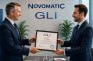 Entrega del certificado GLI de juego responsable a NOVOMATIC Spain entre dos directivos