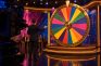 Presentador ante una gran rueda de premios de colores en el plató de un game show de casino