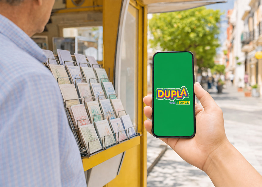 Persona con un móvil que muestra el logo de Dupla de la ONCE ante un quiosco de lotería