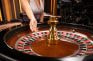 Crupier lanza la bola en una ruleta de casino en vivo ante las cámaras del estudio