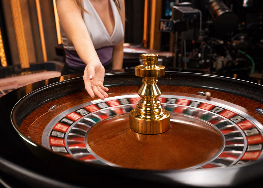 Crupier lanza la bola en una ruleta de casino en vivo ante las cámaras del estudio