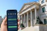 Mano con una app de apuestas frente al Congreso de los Diputados